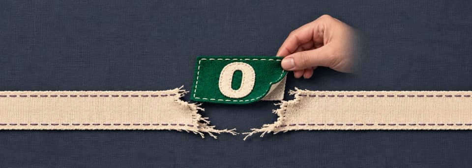A green patch bearing zero is lifted to reveal a missing section of a cream measurement ribbon.